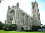 A large stone building with a carillon tower. The building has many turrets, arches, and columns.