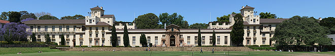 A panoramic photograph of the Physics Building from across playing fields called The Square.